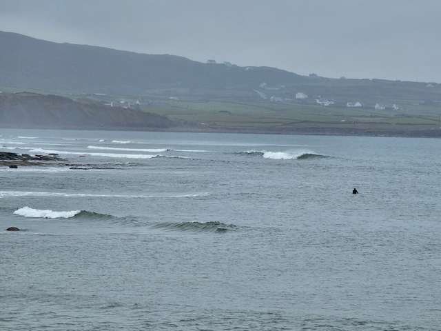 Decent swell on the reefs as one surfer sits and waits for a wave